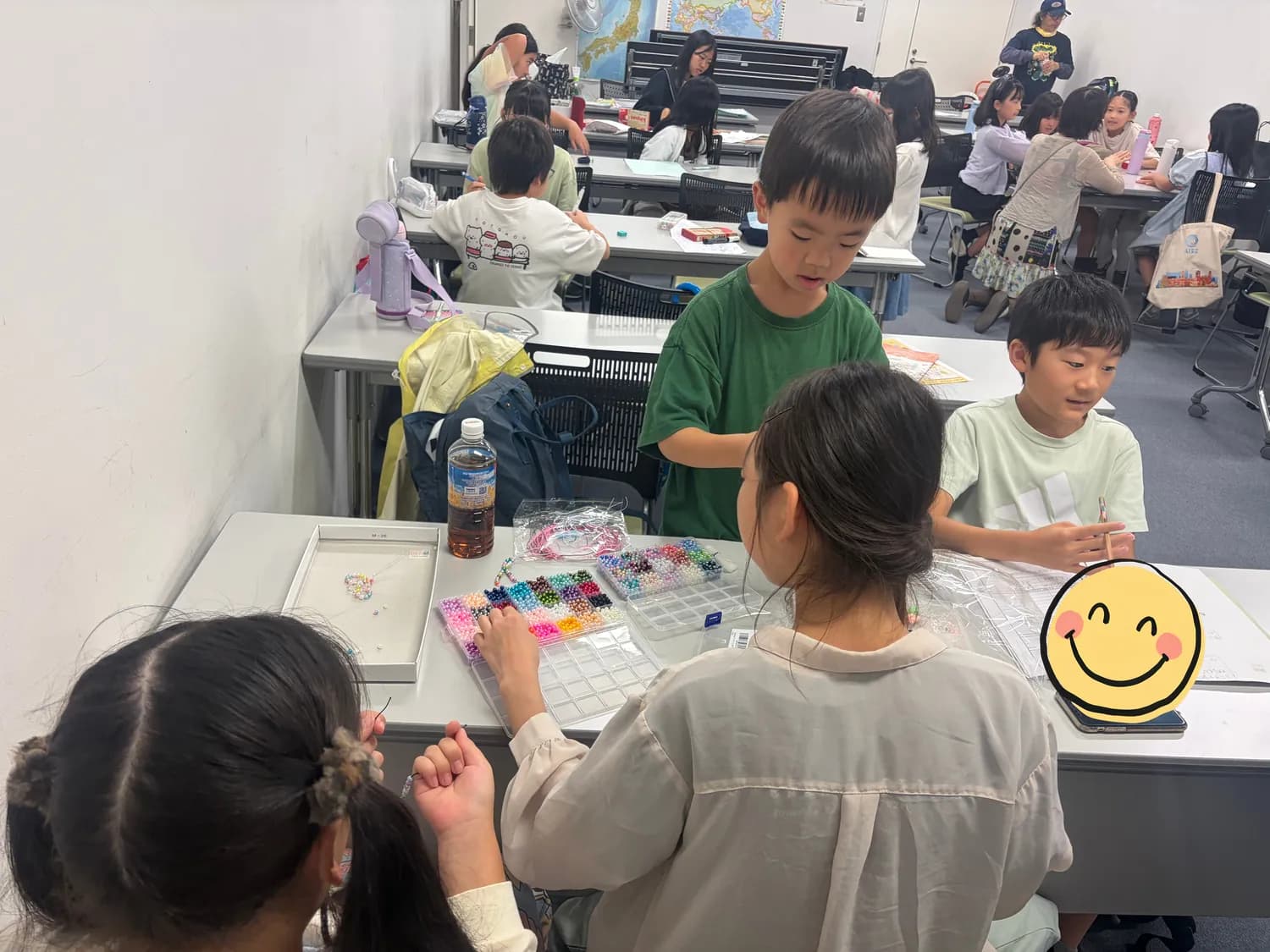 ビーズを使ってお店で売る商品づくりを試している子どもたち