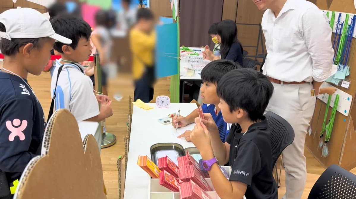 銀行の窓口でミニヨンの手続きをする子どもたち