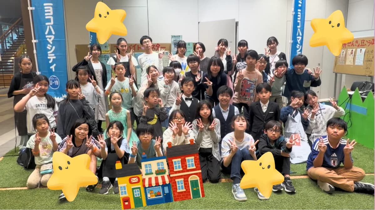 ミニヨコハマシティ2026の集合写真。子どもたちとスタッフがピースサインをしている